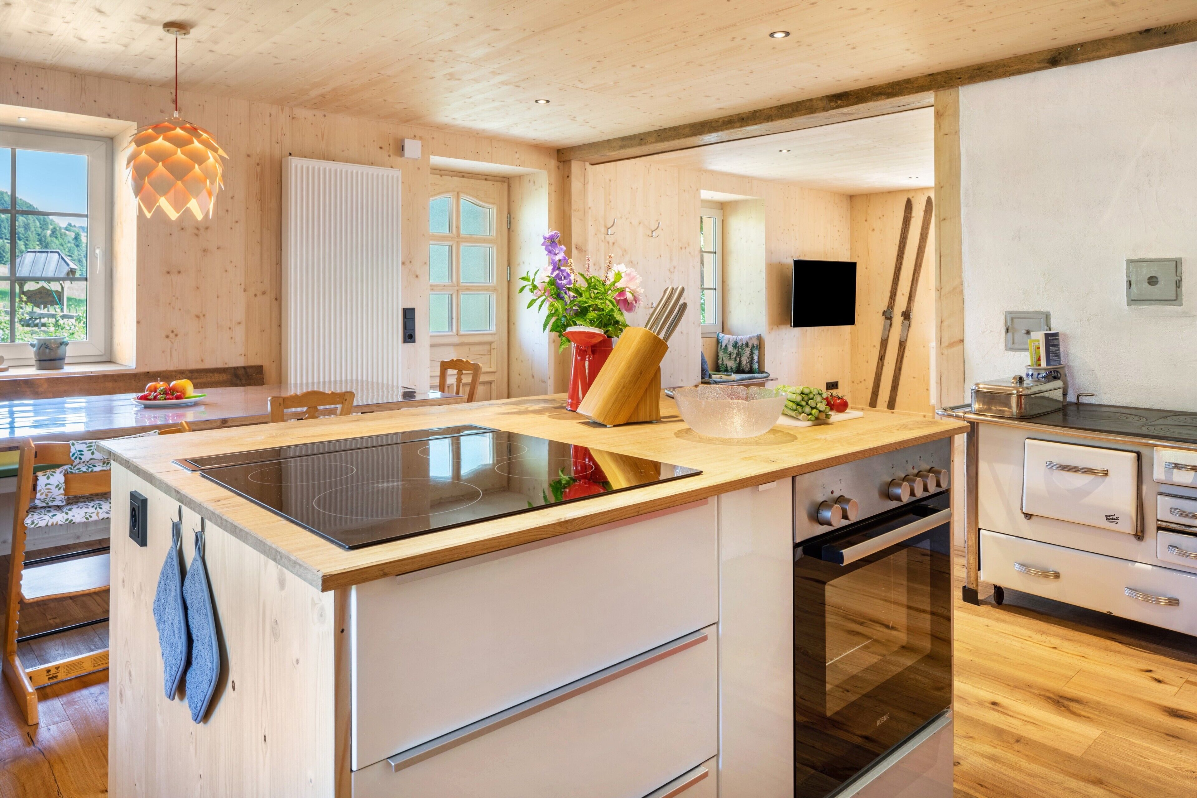 Una cocina moderna con una isla central, armarios de madera y un horno empotrado.