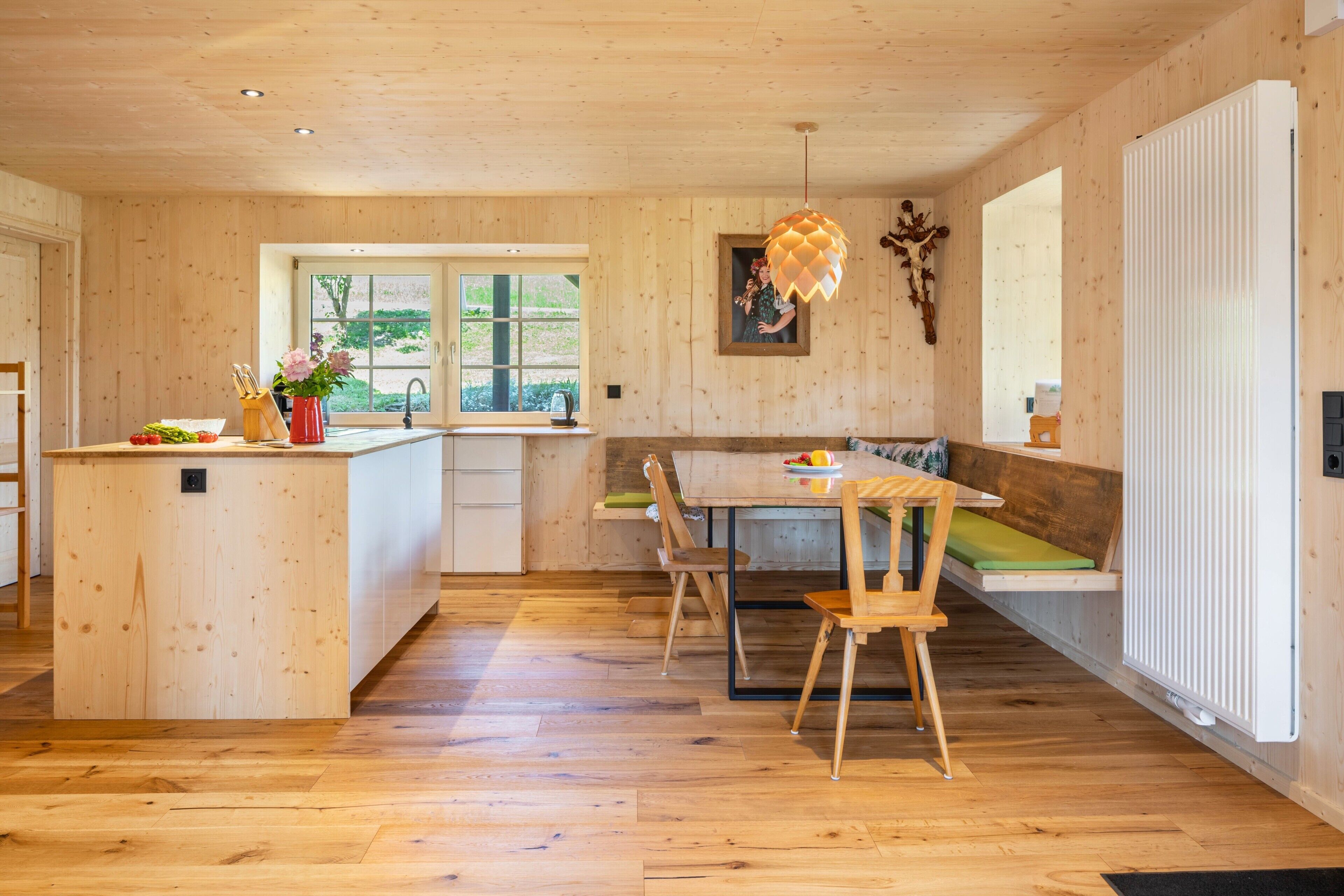 Ein Holzinterieur mit Küche, Essbereich und Sitzgelegenheiten.
