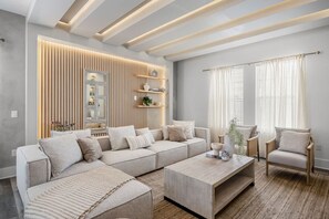 Un saló modern amb un sofà modular, una taula de centre i un moble d'emmagatzematge encastrat amb objectes decoratius.
