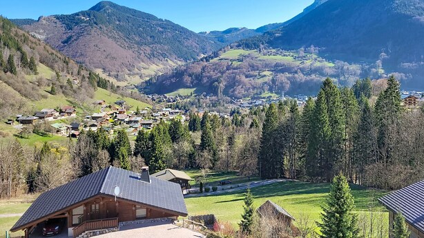 Paisagem montanhosa com uma aldeia e uma igreja imponente.
