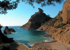 Paesaggio costiero con scogliere rocciose e un mare blu cristallino.