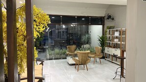 Un interior moderno con una zona de estar, un ventilador y un separador de vidrio.