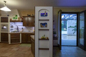 A kitchen with wooden cabinets, a built-in oven, and a sink. - Villa Monica - Private Spacious Villa with 15m Pool near Polignano a Mare (Bari)