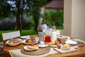 An outdoor dining table with various food items and beverages, surrounded by greenery. - Villa Monica - Private Spacious Villa with 15m Pool near Polignano a Mare (Bari)