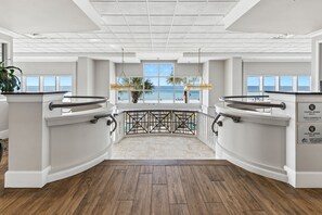 A spacious room with a curved balcony, large windows, and a view of the beach. - The Inn At Crystal Beach Ph 702 4 Bedroom Condo (Destin)