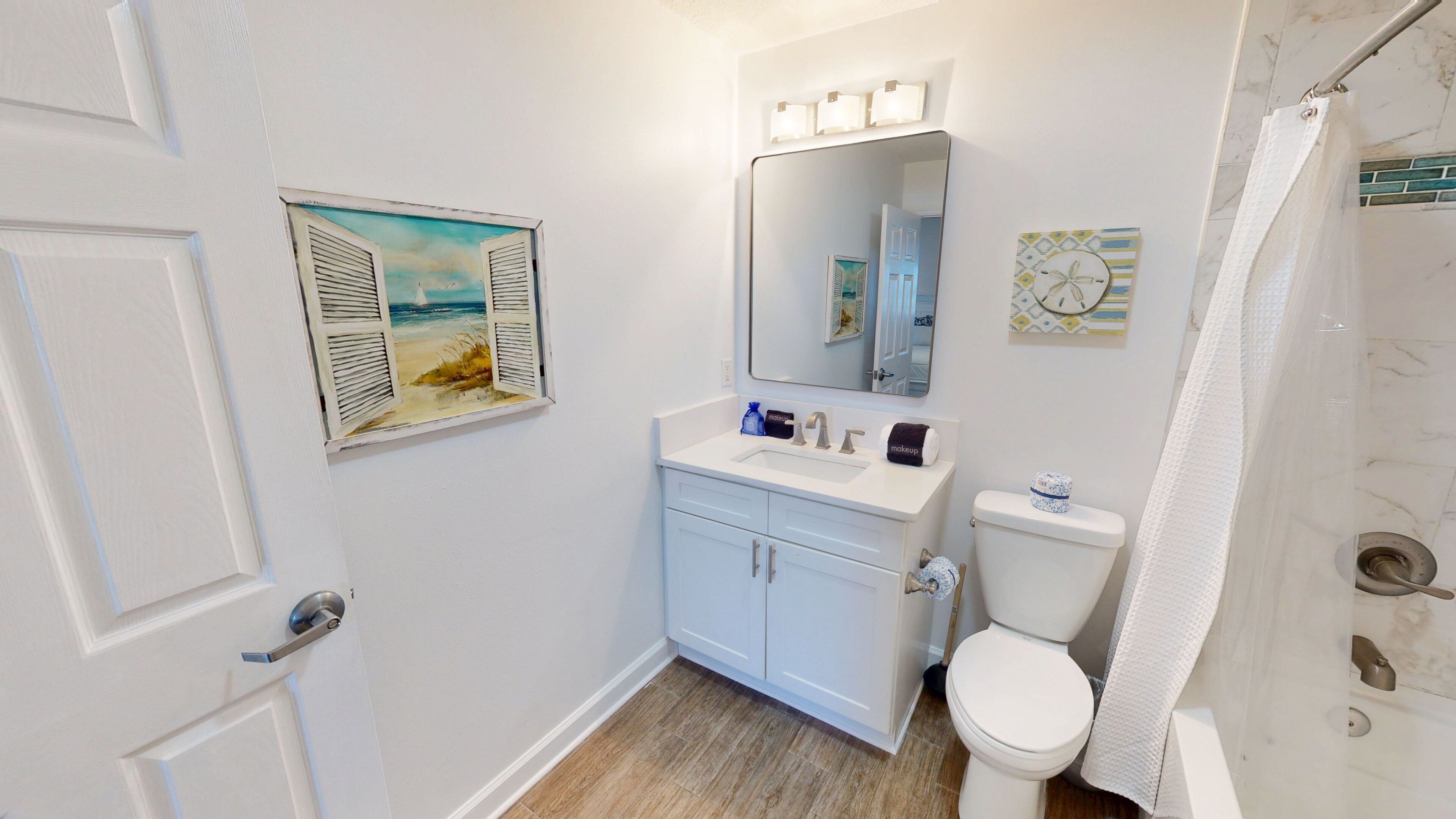 A bathroom with a toilet, sink, and shower curtain.