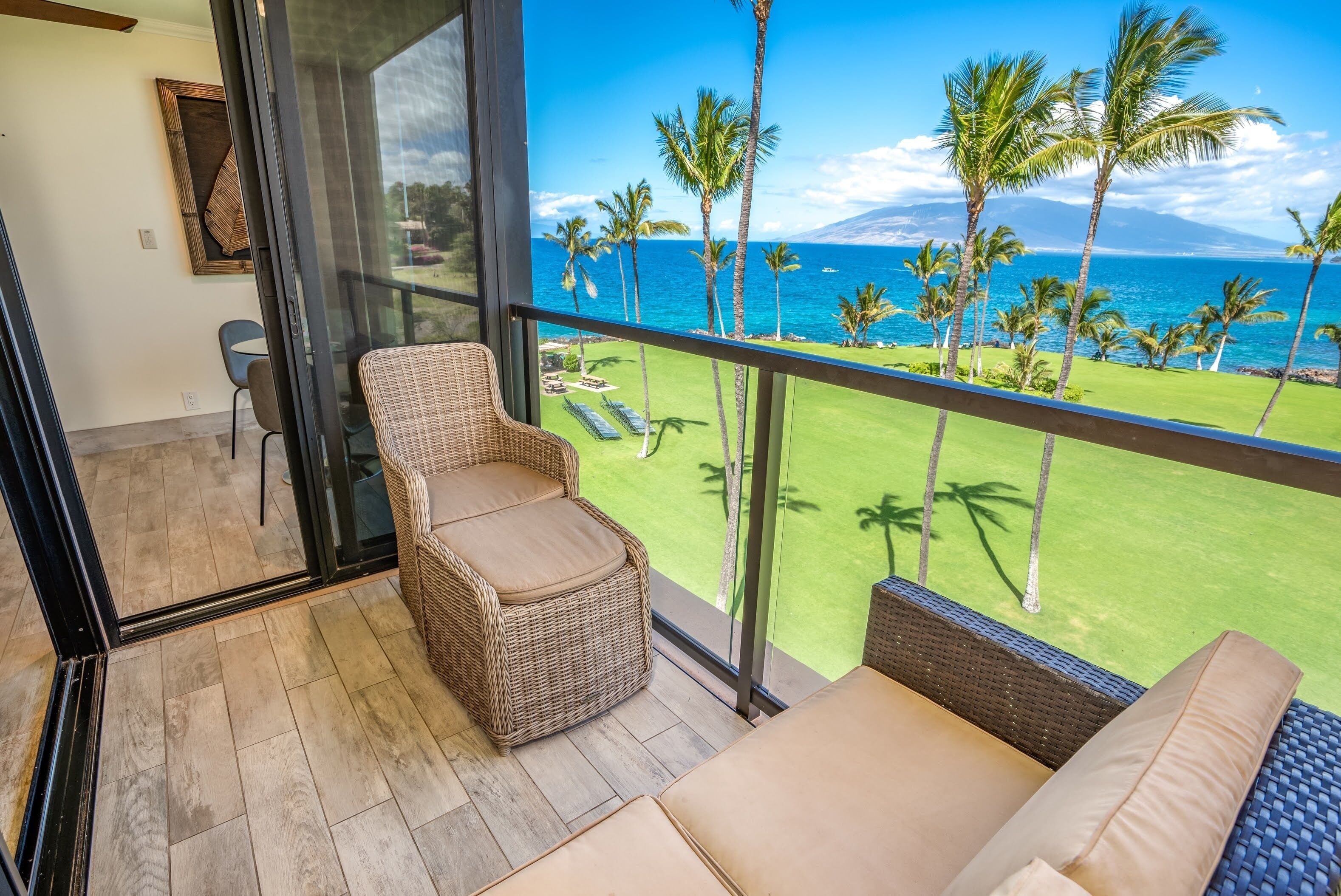 A balcony with wicker furniture and a view of the ocean.