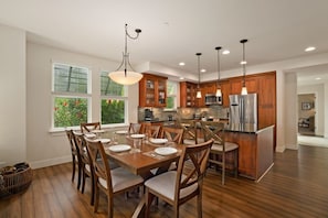 A modern kitchen with wooden cabinets, a central island, and pendant lighting. - Kauai Pili Mai 4k 3 Bedroom Condo (Koloa)
