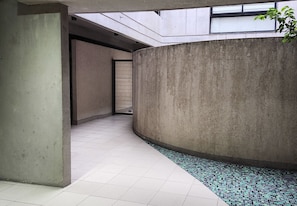 A corridor with a concrete wall, tiled floor, and a small tiled area. - Palermo: Stylish Deco in a Functional Studio with Balcony (Buenos Aires)
