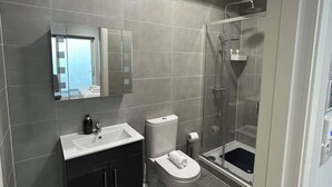 Une salle de bain moderne équipée de toilettes, d’un lavabo et d’une douche.