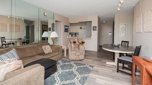 A living room with a sofa, armchair, and dining table. - Oceanfront Building With Great Ocean and Bay Views (Ocean City)