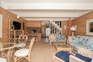 A wooden interior with a dining area, sofa, and kitchen. - Large Oceanside Townhouse (Ocean City)