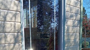 A house with a large window, wooden siding, and a gravel driveway. - La Parenthèse enchantée (Le Vast)
