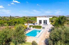 Une villa moderne dotée d’une piscine, d’un espace extérieur aménagé et offrant une vue sur le paysage environnant.