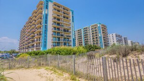 A beachfront hotel with multiple floors, balconies, and a sandy beach area. - Oceanfront Building With Great Ocean and Bay Views (Ocean City)