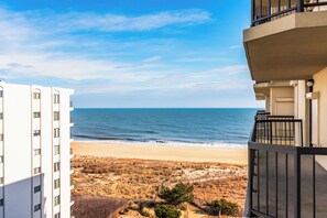 Uitzicht op het strand vanaf een balkon, met zicht op het zandstrand en de oceaan.