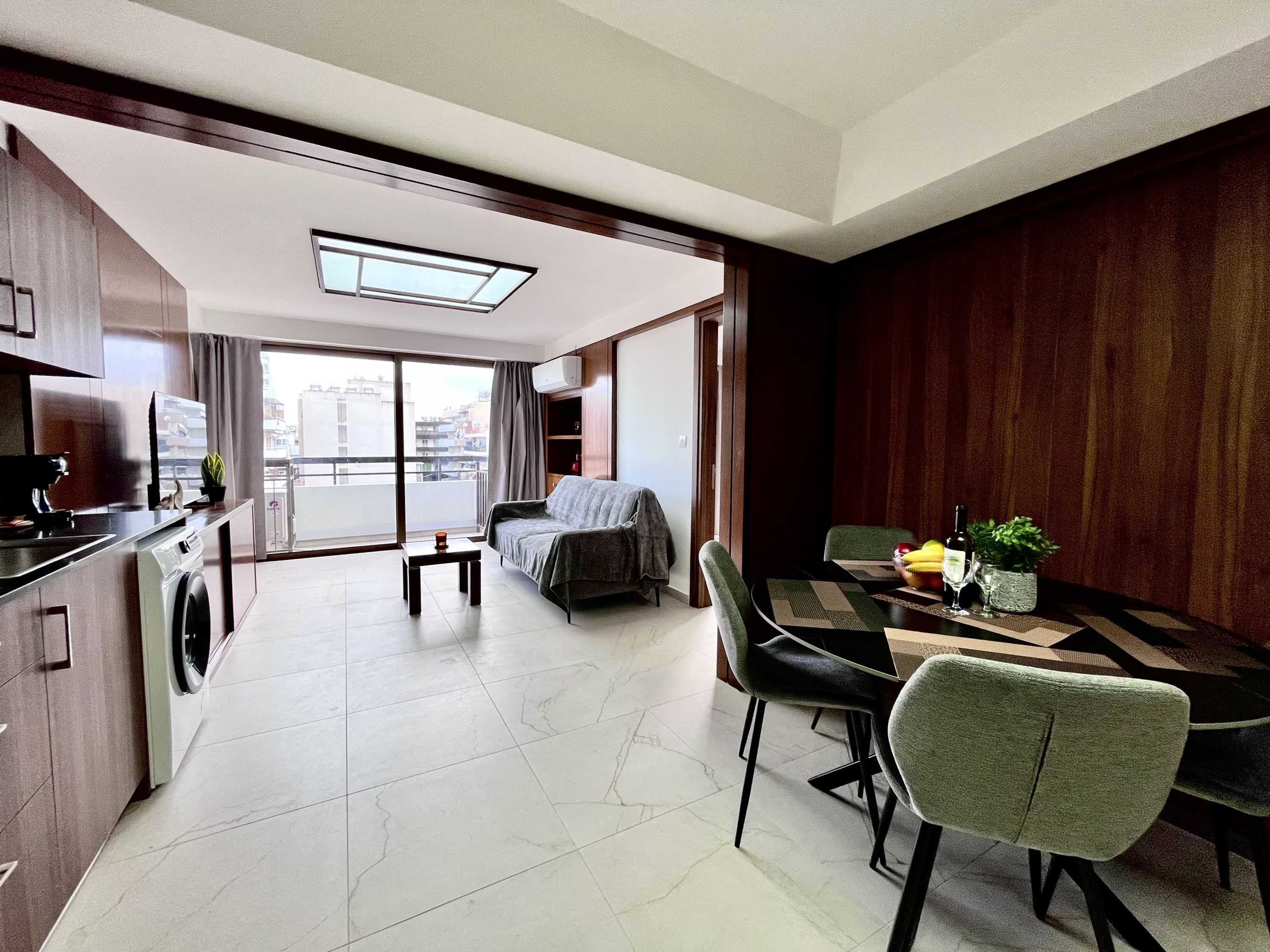 Ein modernes Apartment mit Küchenzeile, Essbereich und einer Couch.