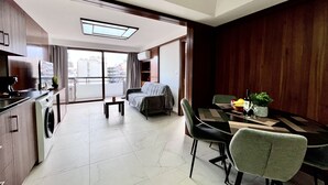 Un apartamento moderno con kitchenette, comedor y sofá.