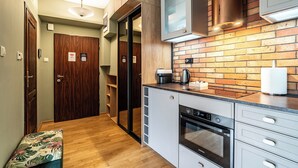 Una cocina moderna con protector mural de ladrillo, electrodomésticos de acero inoxidable y un banco de madera.