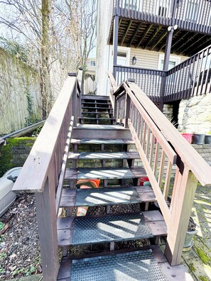 A wooden staircase with metal steps leading to a covered area with a railing. - 2-bedroom apartment in lovely Pittsburgh with parking and breathtaking view (Pittsburgh)
