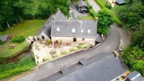 A house with a sloped roof, a paved driveway, and a small garden area. - Room 'Chambre Campagne' with Shared Pool, Shared Terrace and Wi-Fi (Saint-Avé)