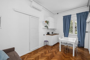 A compact living space with a kitchenette, a dining area, and a sofa. - "3 Beds Duomo Square "Modern House+6 Pax By KeyHost (Milano)