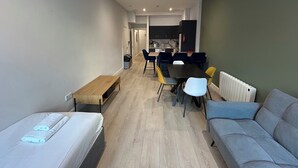 Un appartement moderne comprenant un coin repas, une kitchenette et un canapé.