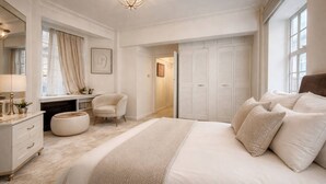 A bedroom with a large bed, a desk, a chair, a wardrobe, and a mirror. - Luxury Pad for Couples Next to Paddington Station (London)