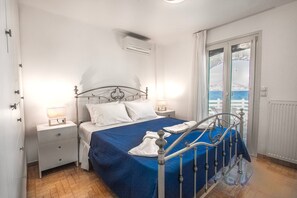 Ein Schlafzimmer mit Bett, Nachttischen, einem Fenster mit Blick und einer Klimaanlage.