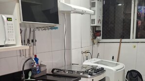 Une cuisine équipée d’un four à micro-ondes, d’une cuisinière et d’un évier. Une fenêtre offre une vue sur l’extérieur.