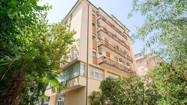 A multi-story building with balconies, surrounded by greenery. - Only Room Hotel  (Lido di Savio)
