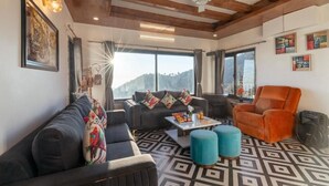 Una sala de estar con un sofá, un sillón, un reposapiés y una mesita de centro.