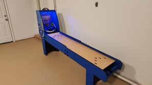 A blue foosball table with a digital scoreboard and a wooden table in front.