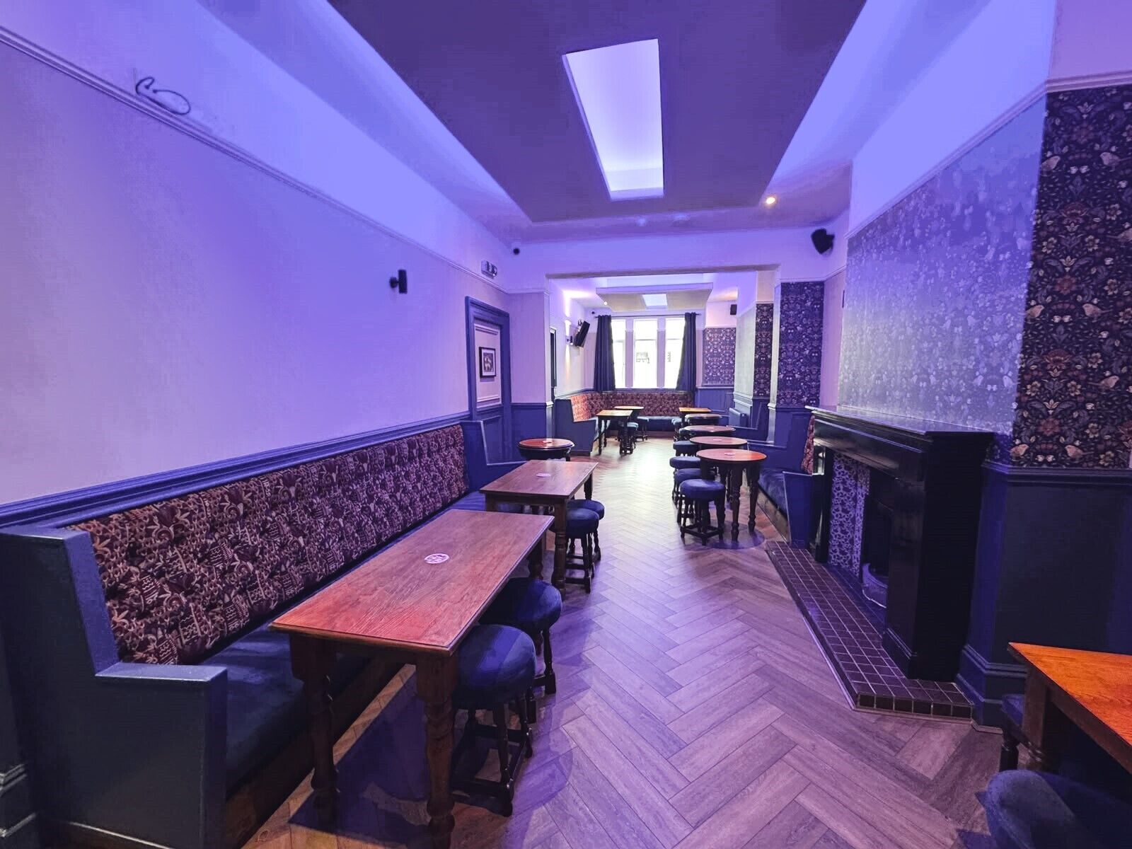 A restaurant interior with booths, tables, and a fireplace.