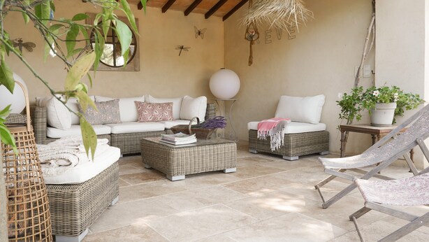 A cozy outdoor seating area with wicker furniture, a hanging light fixture, and a potted plant. - Les Olivandes Cottage with Pool (Saint-Cannat)