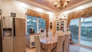 A kitchen with a refrigerator, microwave, and dining table with chairs.