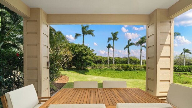 Een houten tafel met vier stoelen, uitzicht op een golfbaan en palmbomen.