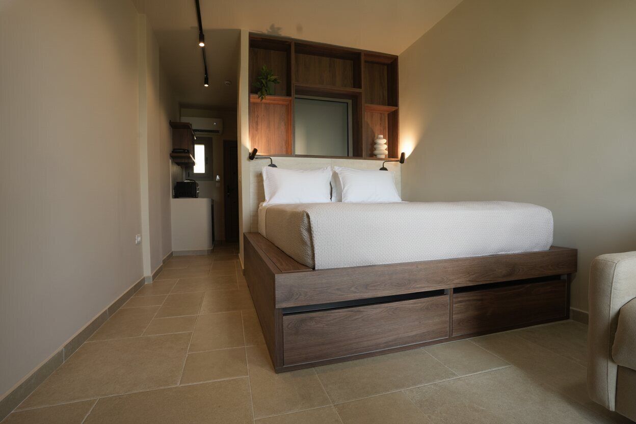 A bedroom with a bed, wooden headboard, built-in shelves, and a small plant.