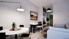 Un intérieur moderne avec une table de salle à manger ronde, deux chaises, un canapé, une table basse et des luminaires suspendus.