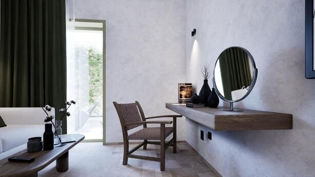 Une pièce moderne comprenant un canapé, un fauteuil, une table basse, un miroir et une étagère avec un livre.
