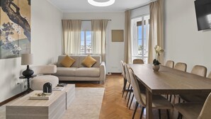 Ein modernes Wohnzimmer mit Sofa, Couchtisch, Esstisch und Stühlen.