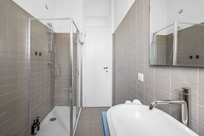 Et moderne badeværelse med bruser, toilet og badekar.