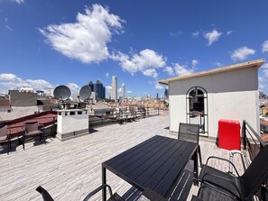 A rooftop terrace with a table and chairs, a small white building, and a cityscape in the background. - Chic & Cozy 2BR – Nişantaşı (Istanbul)