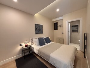 A bedroom with a bed, bedside table, lamp, and a wall-mounted artwork. - Chic & Cozy 2BR – Nişantaşı (Istanbul)