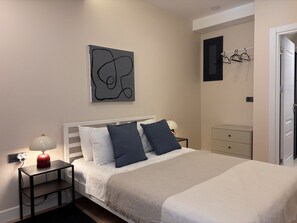 A bedroom with a bed, bedside tables, a lamp, a wall art piece, and a wardrobe. - Chic & Cozy 2BR – Nişantaşı (Istanbul)