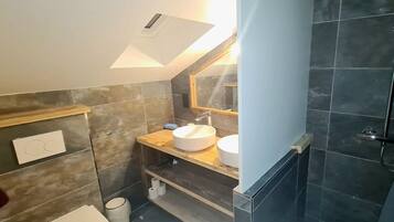 Ein kleines Badezimmer mit Toilette, Waschbecken und Duschbereich.