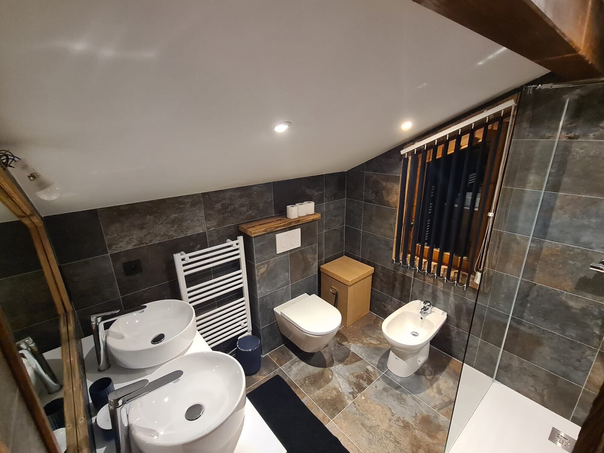 Un bagno moderno con due lavabi, un water, un bidet e una doccia.