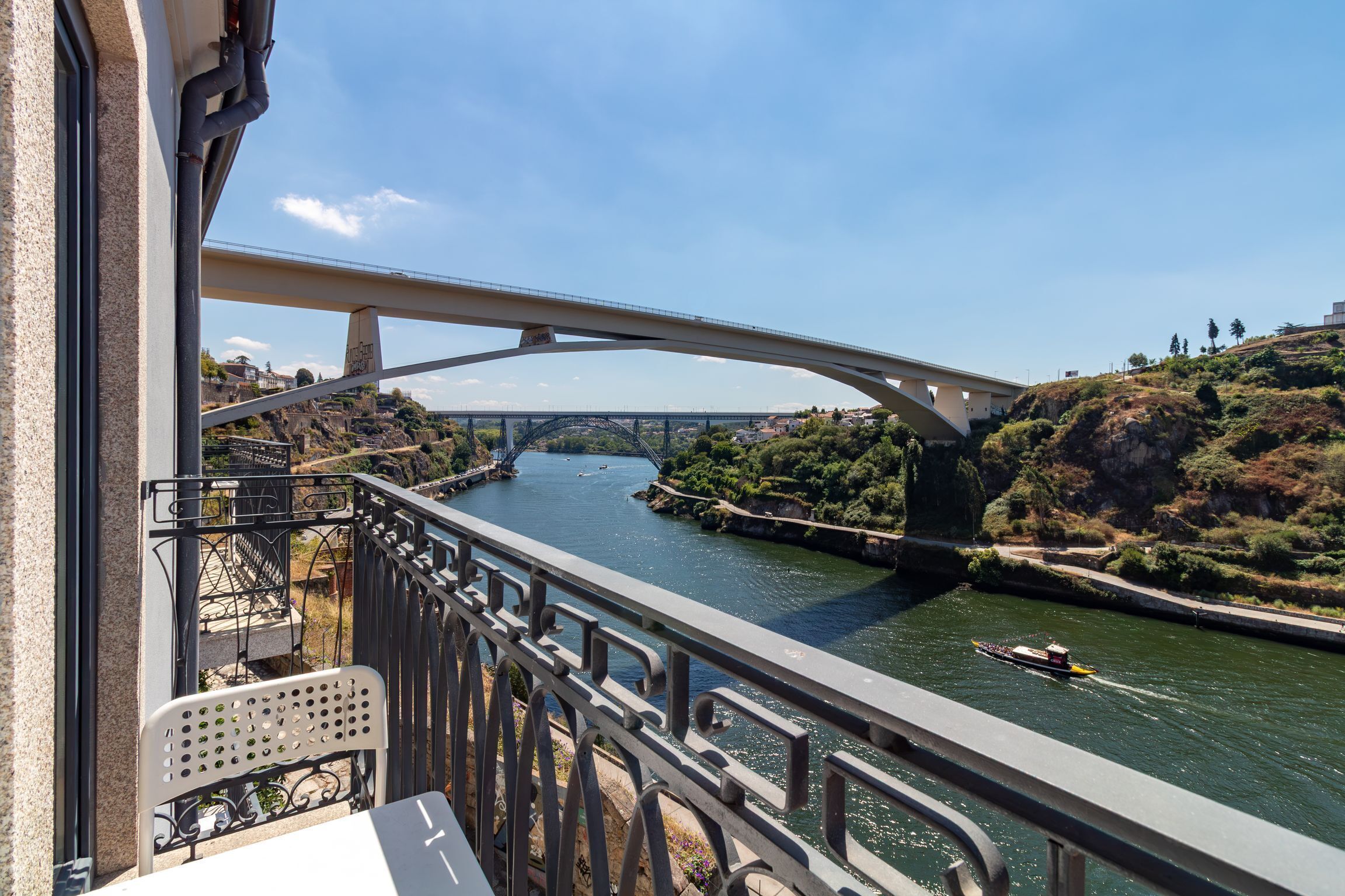 Un río con un puente, una barca y una barandilla.