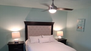 A bedroom with a bed, two bedside tables with lamps, a ceiling fan, and a wall-mounted painting. - Desert Sunshine Lagoon, Beautiful 2 bed 2 bath house with pool and amazing patio (Yuma)