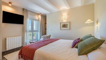 Une chambre d’hôtel avec un lit, une télévision, une fenêtre et une chaise.
